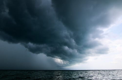 a large storm moving across the sky over a body of water