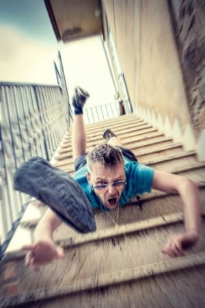 man in blue t-shirt and blue denim shorts sitting on concrete stairs during daytime